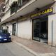 Auto blu parcheggiata davanti a un concessionario chiamato "ABIEFFE-CARS" in una strada cittadina.