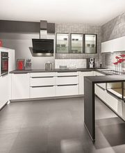 Cucina moderna con mobili bianchi, dettagli rossi e elettrodomestici in acciaio inox.