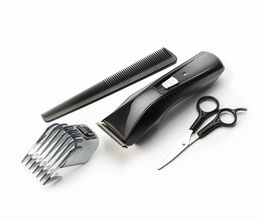 Set taglio capelli: pettine nero, tagliacapelli, forbici e accessorio regolatore.