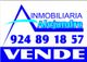 Letrero de Inmobiliaria Alejandre en azul y blanco con número de teléfono y texto "VENDE".