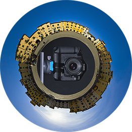 Kugelpanorama mit einer Kamera im Zentrum, umgeben von Gebäuden und blauem Himmel.