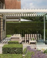 Moderne Terrasse mit Pergola, Sitzbereich und gepflegtem Garten.