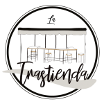 Logotipo circular con mesas de madera bajo una carpa y la palabra "Trastienda".