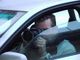 Person mit Kamera im Auto, fotografiert durch das geöffnete Fenster.