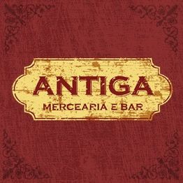 Placa envelhecida com os dizeres: "Antiga Mercearia e Bar" em fundo vermelho com bordas decorativas.