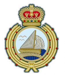 Abzeichen mit Segelschiff, Krone und goldener Verzierung auf blauem Hintergrund.