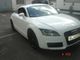 Ein weißer Audi TT steht auf einem Parkplatz, leicht von der Vorderseite fotografiert.