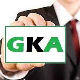 Pessoa segurando um cartão com as letras "GKA" em verde e preto.