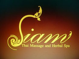 Der Schriftzug "Siam Thai Massage and Herbal Spa" in goldener Schrift auf braunem Hintergrund.
