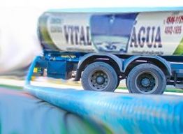 Caminhão de transporte de água com a inscrição "Vital Água" visível na lateral.