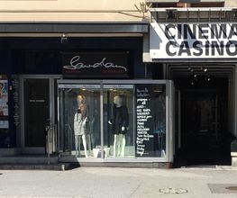 Geschäft mit Schaufensterpuppen neben einem Kinoeingang mit Schild "CINEMA CASINO".