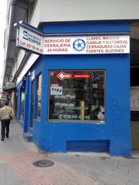 Tienda azul de cerrajería con letrero de servicio 24 horas y aviso de llave al instante.