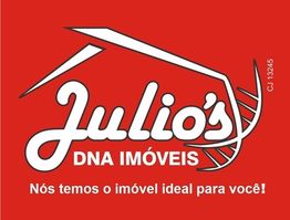 Placa vermelha com texto: "Julio’s DNA Imóveis - Nós temos o imóvel ideal para você!"