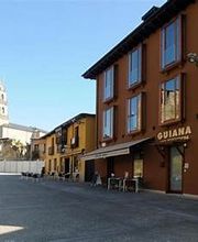 Frente de edificios coloridos con iglesia y cielo azul al fondo en una calle peatonal.