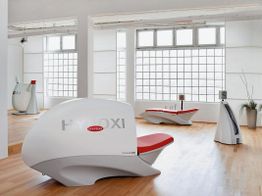 Fitnessstudio mit HYPOXI-Geräten in hellem Raum mit Holzboden und großen Fenstern.