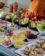 Mesa con variedad de aperitivos: frutas, verduras, carnes y ensaladas. Comida decorativa.