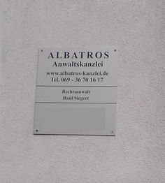 Schild mit Aufschrift: "ALBATROS Anwaltskanzlei" und Kontaktinformationen.