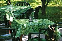 Garten mit grünen Tischen und Stühlen, darauf stehen Gläser.