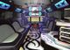 Luxurious limousine interior with LED lights, spacious seating, and a small bar area.