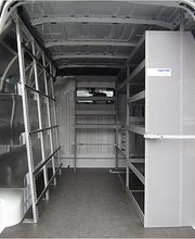Der Innenraum eines weißen Transporters mit Regalen und Staufächern.