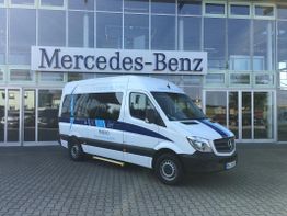 Ein weißer Mercedes-Benz Kleinbus steht vor einem Mercedes-Benz Gebäude.