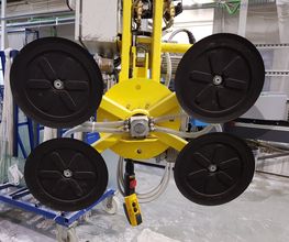 Gelbes, industrielles Vakuum-Hebezeug mit vier schwarzen Saugnäpfen in einer Werkstatt.