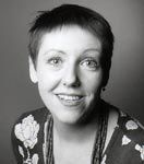 Frau mit kurzen Haaren lächelt in die Kamera, schwarz-weiß Foto.