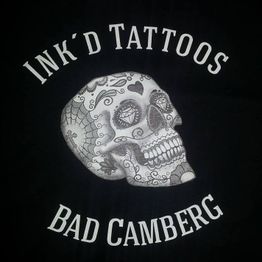 Illustration eines verzierten Schädels mit Schriftzug "INK'D TATTOOS BAD CAMBERG".