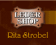 Braunes Lederschild mit Text: "Leder Shop Rita Strobel" in Weiß und Gelb.