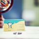 Dental clinic business card on a table with a blurred colorful object in the background.
