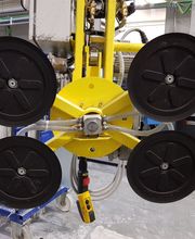 Gelbes, industrielles Vakuum-Hebezeug mit vier schwarzen Saugnäpfen in einer Werkstatt.