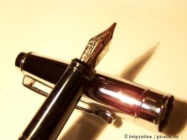 Füllfederhalter in Nahaufnahme mit glänzender Kappe und filigraner Feder auf hellem Hintergrund.