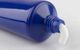 Blue tube with white cream oozing from the open nozzle on a light background.