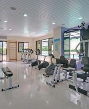 Academia espaçosa com equipamentos de musculação e bicicletas ergométricas.