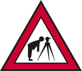 Warnschild mit Mensch, der durch ein Vermessungsgerät schaut, in rotem Dreieck.