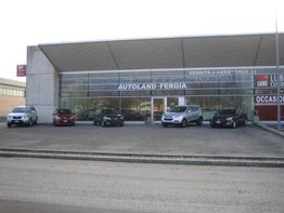 Concessionaria d'auto con cinque veicoli parcheggiati davanti e vetrina con insegna "AUTOLAND-FERGIA".