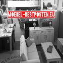 Schwarz-weiß Foto eines Möbelladens mit dem roten Schriftzug "Moebel-Restposten.eu" oben.
