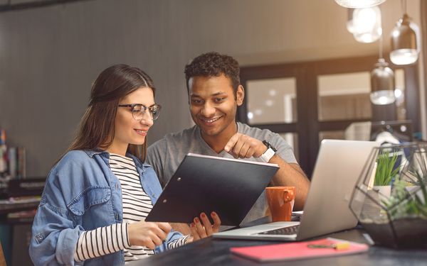 Eine Studentin sitzt zusammen mit ihrem Ghostwriter, als Lernpartner zur Unterstützung, an ihrer Bachelorarbeit.