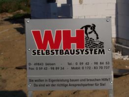 Bauschild mit Kontaktdaten und Text: "WH Selbstbausystem", "richtige Ansprechpartner für Sie".