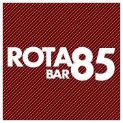 Logotipo do Rota 85 Bar, com texto branco sobre fundo vermelho com listras diagonais.
