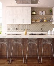 Cocina moderna con encimera blanca, taburetes de metal y estantes con decoración minimalista.