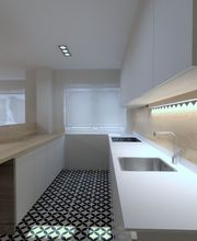 Cocina moderna con encimera blanca, azulejo geométrico y luz cálida bajo gabinetes.
