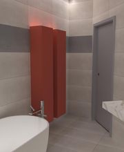 Bagno moderno con vasca bianca, mobile rosso, pareti grigie e lavandino su piano in marmo.