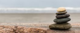 Steinhaufen am Strand mit unscharfem Meereshintergrund.