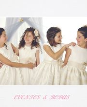 Cuatro niñas sonriendo juntas con vestidos blancos, fondo con cortina azul. Texto: "EVENTOS & BODAS".