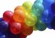 Bunte Luftballons in Regenbogenfarben, die eng nebeneinander angeordnet sind.