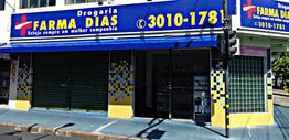 Fachada da Drogaria Farma Dias com placa azul e detalhes amarelos e verdes.