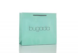 Sacchetto regalo verde acqua con manici neri e scritta "bugada" al centro.
