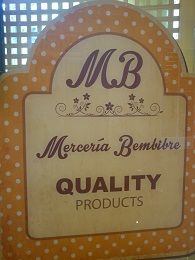 Letrero de Mercería Bembibre, fondo naranja con puntos, texto "Quality Products".