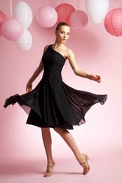 Eine Frau in einem schwarzen Kleid posiert elegant vor rosa Hintergrund mit Laternen.